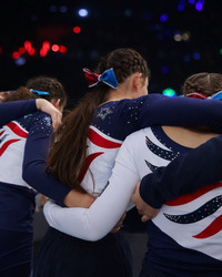 Drei Cheerleader von hinten die sich an den Schultern umarmen